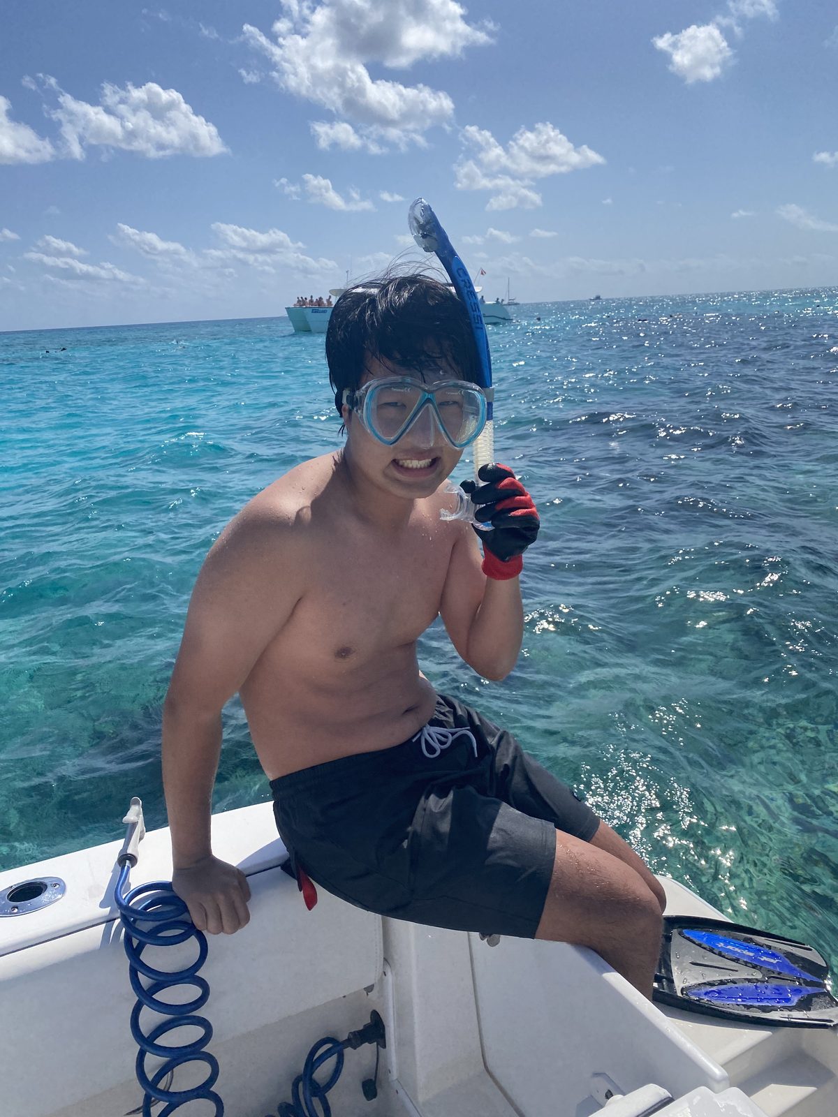 Young guest in snorkel mask aboard the boat