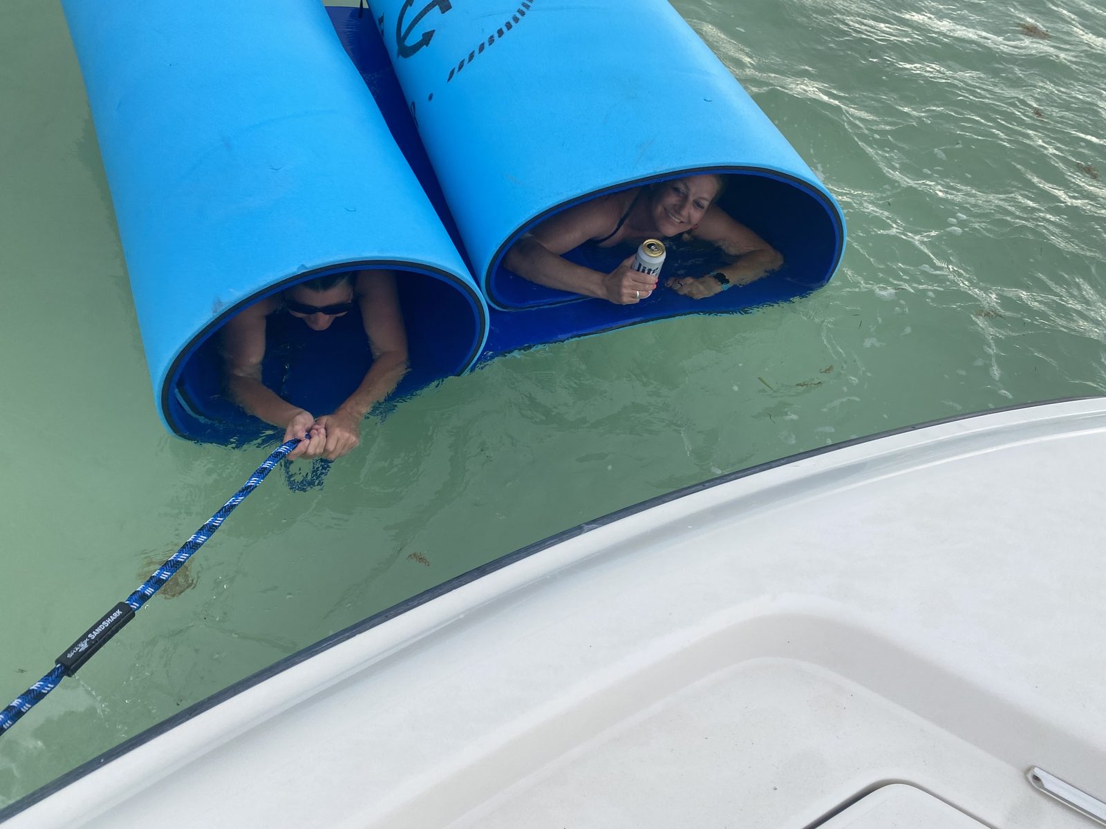 Two guests relaxing on pool noodles at the Islamorada sandbar