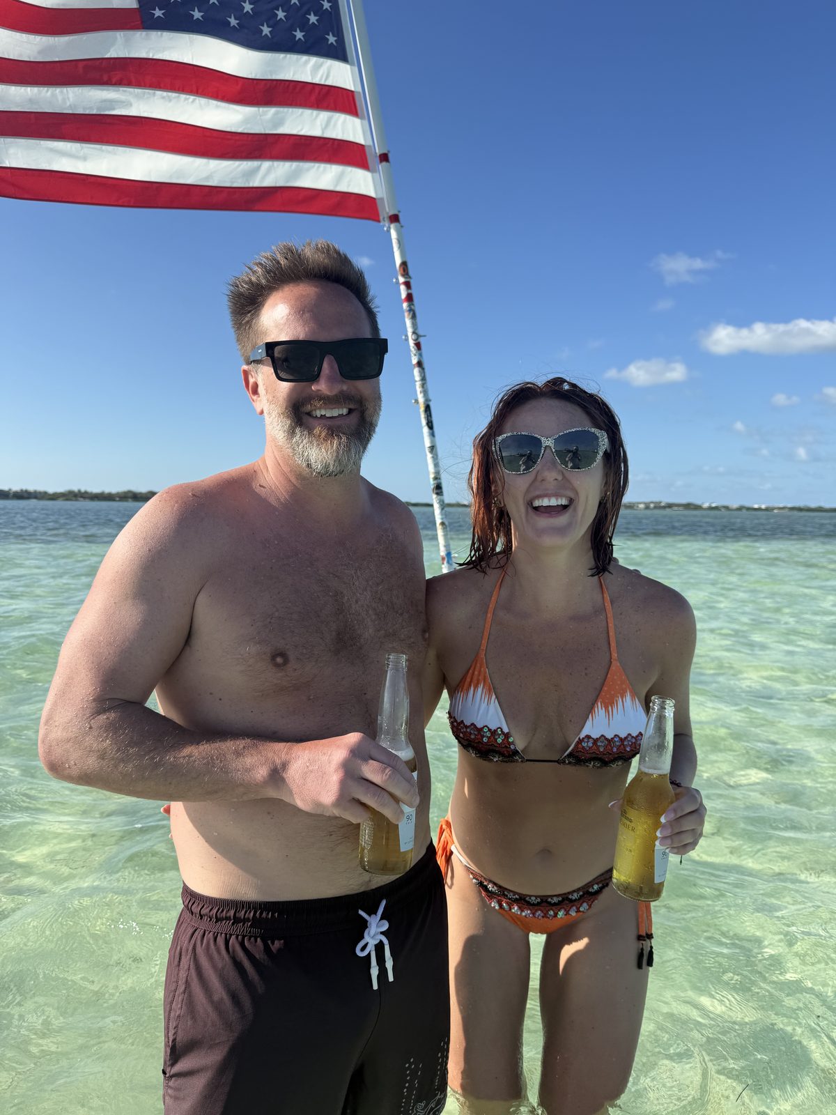 Couple under a US flag at the Islamorada sandbar